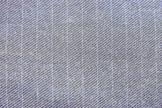 Blue gray twill fabric with diagonal woven texture in close-up. Denim textile for clothing and apparel design. Fashion material, garment making and sewing. Fabric surface for textile design.
