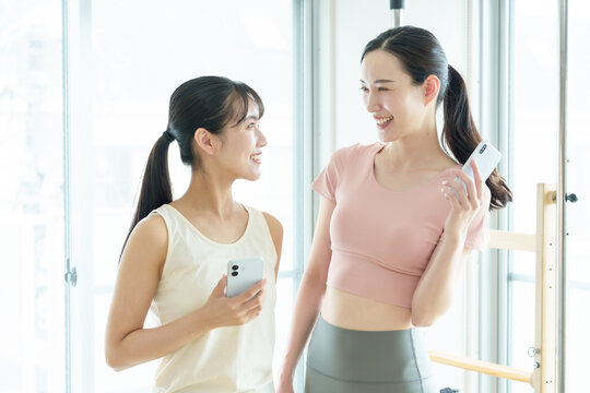 スマートフォンを使う女性　ピラティス、ヨガ、スタジオ