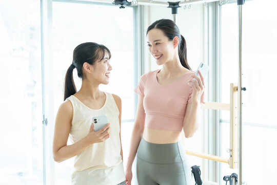 スマートフォンを使う女性　ピラティス、ヨガ、スタジオ