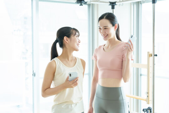 スマートフォンを使う女性　ピラティス、ヨガ、スタジオ