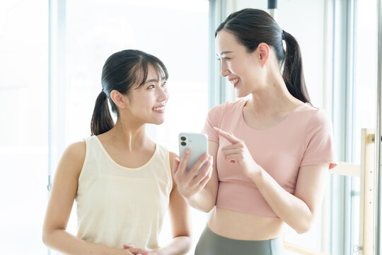 スマートフォンを使う女性　ピラティス、ヨガ、スタジオ