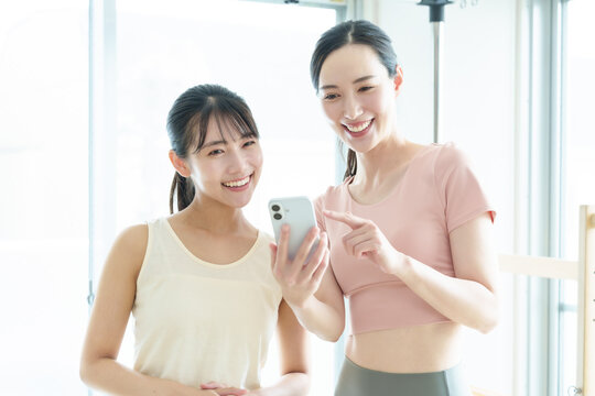 スマートフォンを使う女性　ピラティス、ヨガ、スタジオ