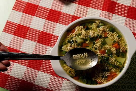 Childhood Education Crisis Concept Showing Brain Rot Spoon Scooping Alphabet Pasta Letters, highlighting the ongoing deterioration of intellectual standards in today's digital generation.