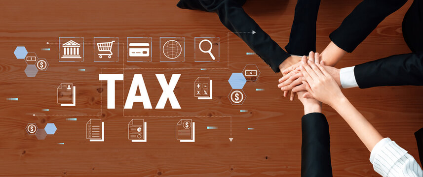 Hands of diverse professionals collaborating on tax planning with digital icons representing finance, documents, and analysis on a wooden table Fluxor.