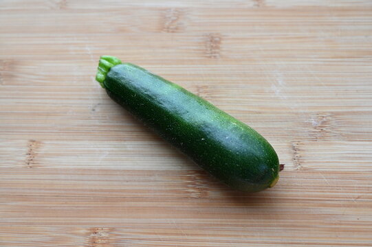 採れたての無農薬ズッキーニ 木のまな板に置いた夏野菜
