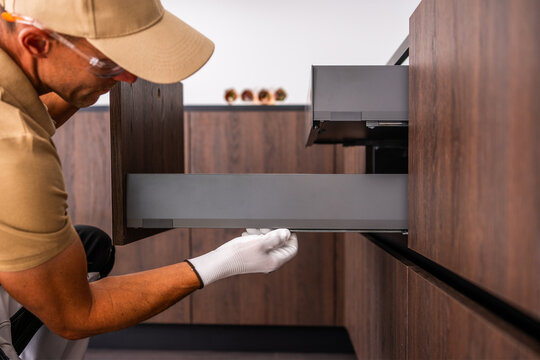 Installer adjusting a drawer during kitchen cabinet assembly