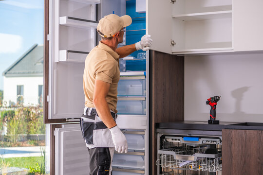 Installer checking a built-in refrigerator in a new kitchen