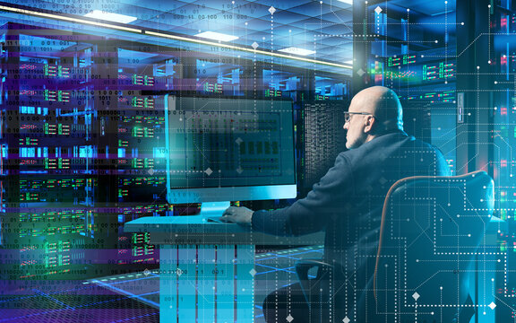 Data center, IT infrastructure. Administrator monitors server systems, network operations and digital data processing in a modern computing facility.