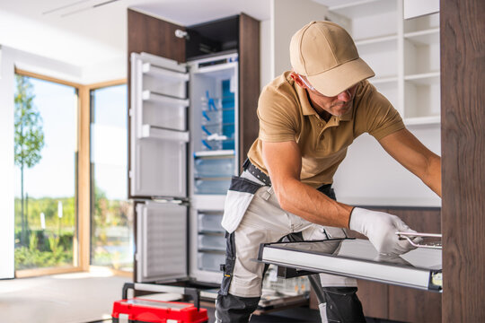 Installer adjusting a pull-out basket in a kitchen cabinet