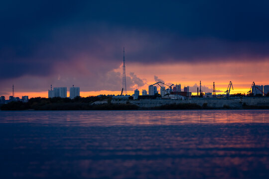 Dramatic sunset over Blagoveshchensk city skyline across Zeya river, capturing vivid sky colors and calm reflective water