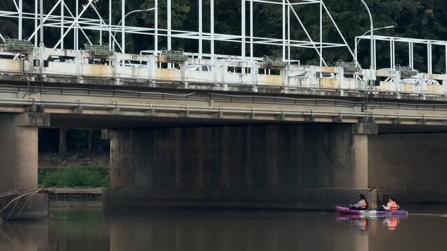 People kayaking under Nawarat  bridge on Ping river in Chiang Mai