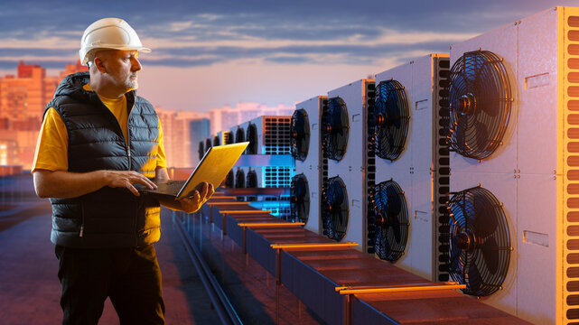 HVAC maintenance, engineer monitors rooftop air conditioning and cooling units with a laptop during inspection of building climate equipment.