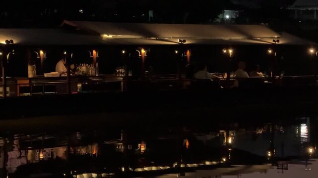 People dining on tourist boat on the Ping River restaurant at night in Chiang Mai