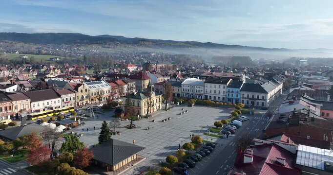 Aerial approach to Nowy Targ Town Hall and Market Square in autumn