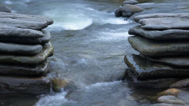 河原の石積みの間を抜ける水 シームレスループ動画背景 16:9 4K