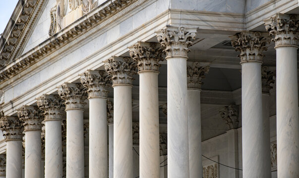 Columns marble Tall vertical exterior. Columns symmetry architectural pattern. Columns decorative capitals carved detail. Columns American Capitol facade.