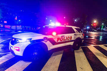 Police SUV on City Street. Emergency Police Lights at Night. Federal Police Patrol Vehicle. Police Car on Wet Street. Law Enforcement SUV at Night. © Svitlana