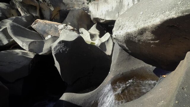 Vale da Lua water cascade flows through smooth weathered quartzite channels and rounded cavities along the Sao Miguel River in the Cerrado of Chapada dos Veadeiros, panning