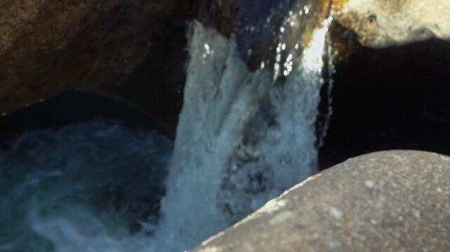 Vale da Lua waterfall flows through deeply eroded quartzite channels and rounded cavities along the Sao Miguel River in the Cerrado of Chapada dos Veadeiros, pan upwards