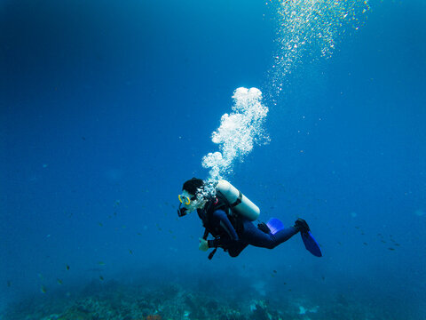 A young scuba diver breathing under water in a blue ocean in the Caribbean

