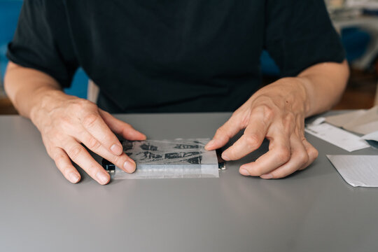 Person hands applying thin, transparent protective film onto smartphone screen, ensuring bubble free fit for enhanced durability and scratch resistance, close-up, cropped shot