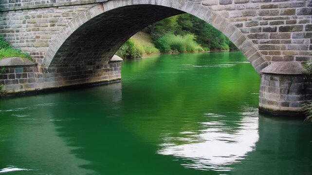 Stone bridge reflection rippling in a river