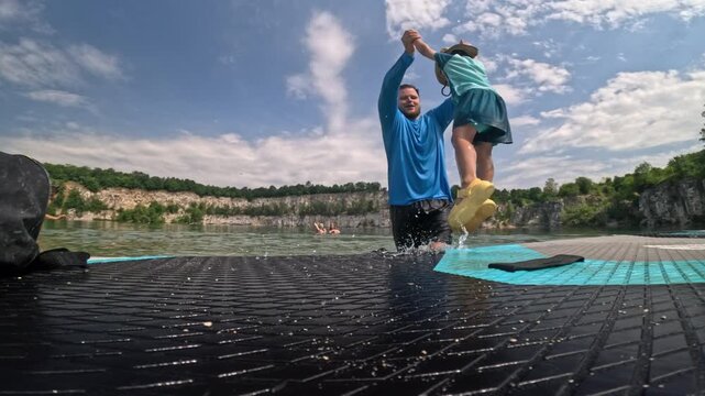 Father and son playing beside a floating paddleboard