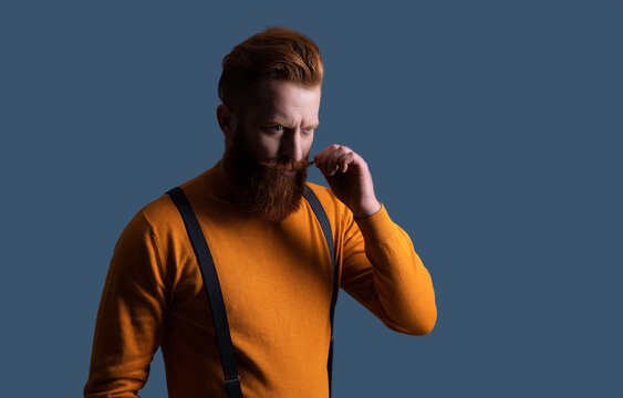 Retro man in suspenders isolated on grey. Mature redhead man with hairstyle. Vintage male fashion style. Male vintage style. Vintage brutality guy with axe in retro suspenders, copy space