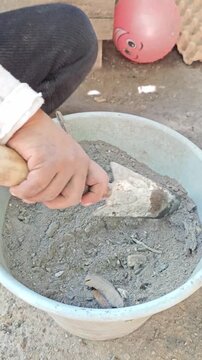 Stirring Grey Fireplace Ash with Small Shovel Tool in Container