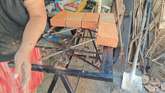 Dust Rising from Clay Bricks as Woman Arranges Them Closely