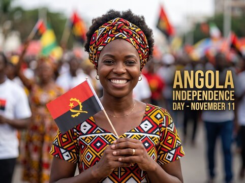 Smiling woman wearing a patterned headwrap and matching holding a small angolan flag during an outdoor independence day celebration with a blurred crowd in the background