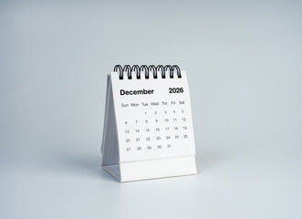 Minimal desk calendar showing December 2026 on a clean gray background, ideal for year-end planning, business schedules, deadlines, appointments, holiday preparation and time management. © tete_escape