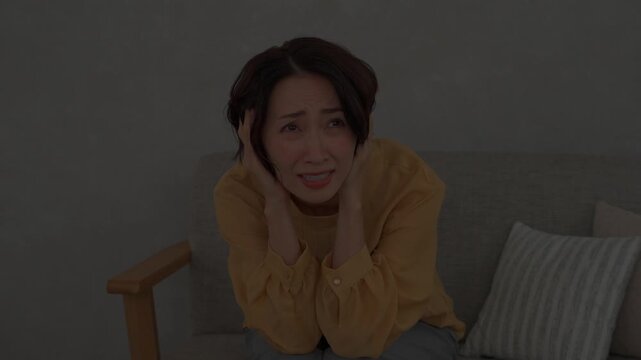 リビングで雷に怯えるミドル女性