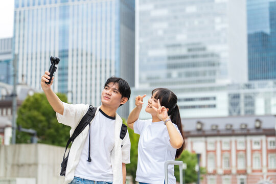 Asian tourists taking selfies with action cameras. Video, live streaming, inbound tourism, foreigners, social media, popular