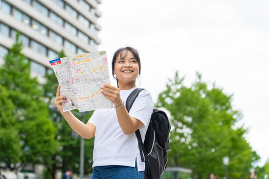 地図を見て旅行するアジア人観光客。インバウンド、笑顔、ガイドマップ、日本、東京、ツアー、外国人、案内