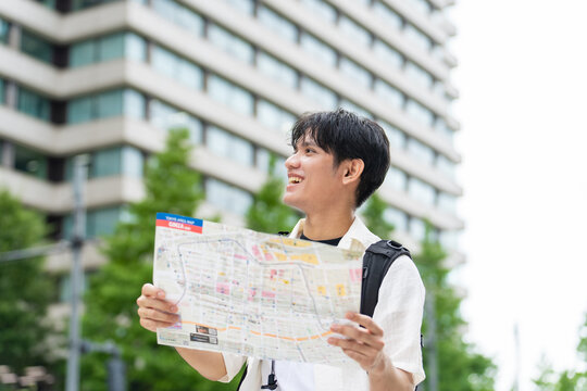 地図を見て旅行するアジア人観光客。インバウンド、笑顔、ガイドマップ、日本、東京、ツアー、外国人、案内