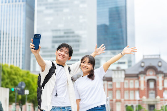 スマホで自撮りするアジア人観光客カップル。動画、ビデオ、配信、インバウンド、外国人、SNS、人気