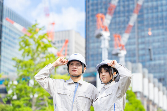 都市の前に立つアジア人労働者。建設、工事、技能実習生、外国人、建築、仕事、東南アジア、作業員、働く