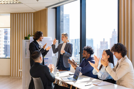 Team of happy diversity business people agreement on deal over new strategic strategy project on investment real estate with recognition and applause from other colleague for partnership