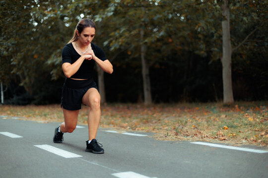 Determined Woman Doing Lunges Workout On Outdoor Forest Pathway. Focused athletic female trainer performs deep lunge exercise during intense outdoor summer workout