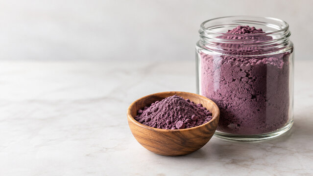 Glass jar of purple comfrey root powder with bowl, herbal remedy concept