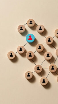 Network of People: A connected network of circular wooden tokens, each featuring a silhouette of a person, illustrates a web of relationships, with one red-capped figure at the center.