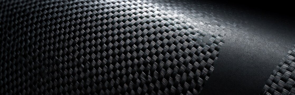 Close up of woven carbon fiber material abstract texture dark industrial background