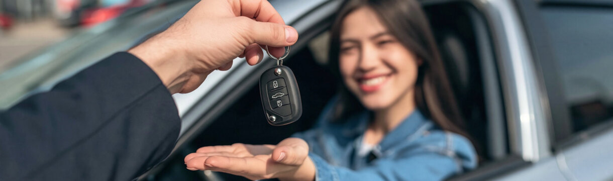 Car Key Handover: A young woman, beaming with excitement, receives the car keys from a salesperson, symbolizing new beginnings and the freedom of the open road.