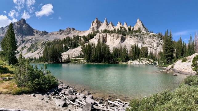 Alpine lake with jagged mountain peaks and pine forest