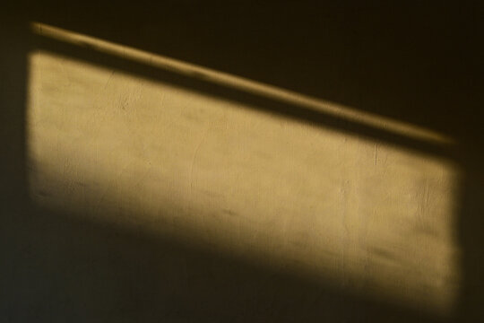 Yellow wall interior background, studio and backdrops show products.with shadow from window color. background for text insertion and presentation product. Black. Dark. Copy space, empty. Beige