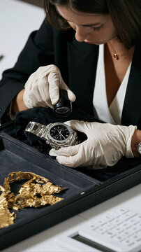 Jewelry Appraisal Expertise: A skilled appraiser, wearing white gloves, meticulously examines a luxurious diamond-encrusted watch with a magnifying glass.