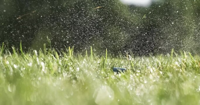 Golf club striking ball on wet grass, close up slow motion footage of sports action.