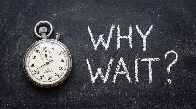 Stopwatch on a black chalkboard with the text why wait written in white chalk, concept of urgency, time management, and procrastination