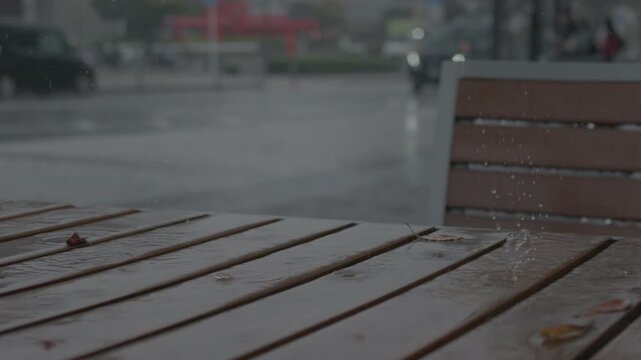 木製の机の上に雨粒が落ちる様子　雨　スローモーション
